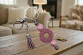 Pink daisy beaded keychain charm with tassel in cozy living room setting