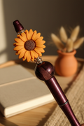 Terracotta-orange flower beaded pen in warm earthy home setting