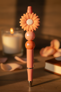 Peach flower beaded pen in warm cozy home setting